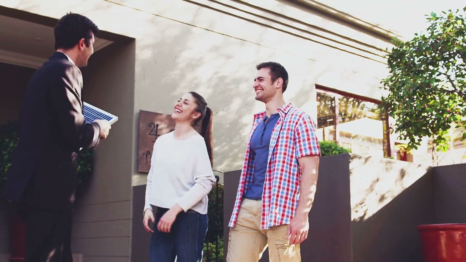 A solar representative greeting homeowners outside their home