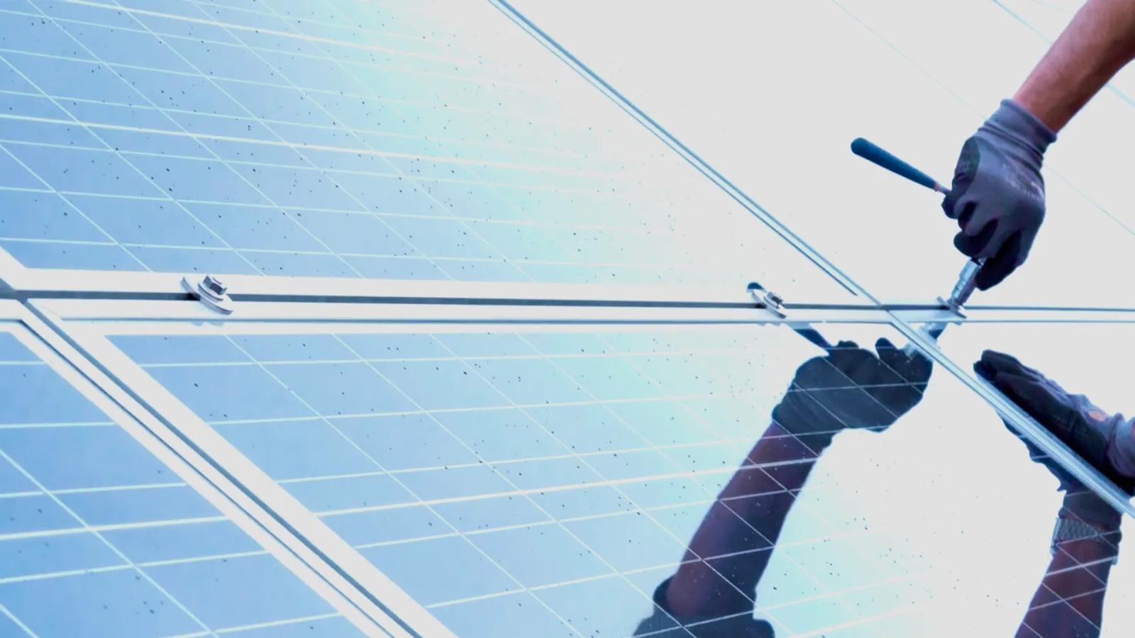 Installer fastening mounting hardware to solar panels