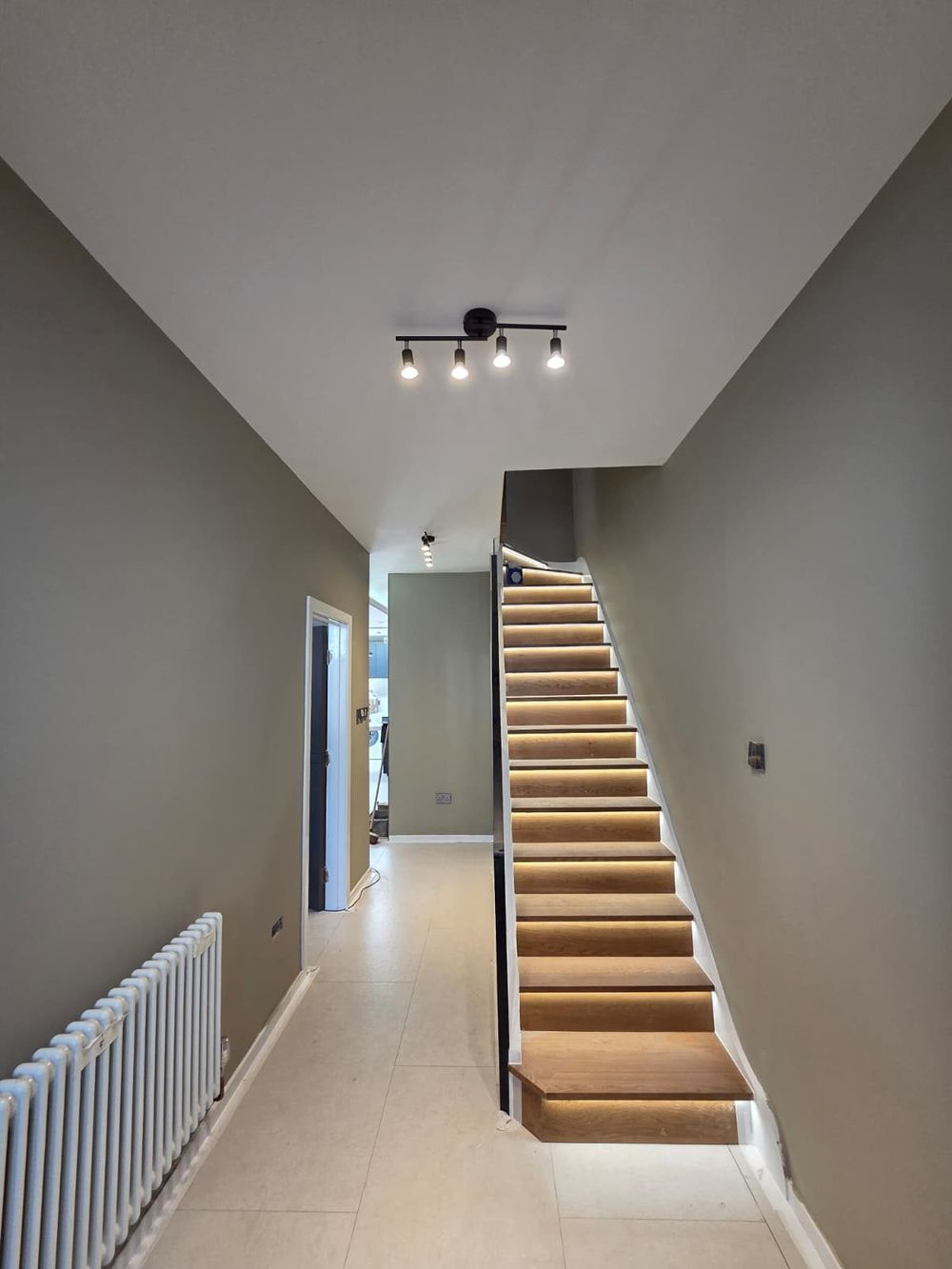 Hallway with illuminated staircase — Full House Renovation by TrustBuilt Projects