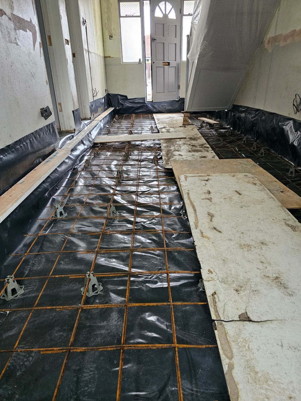 Before — floor membrane and rebar — Hallway Transform by TrustBuilt Projects