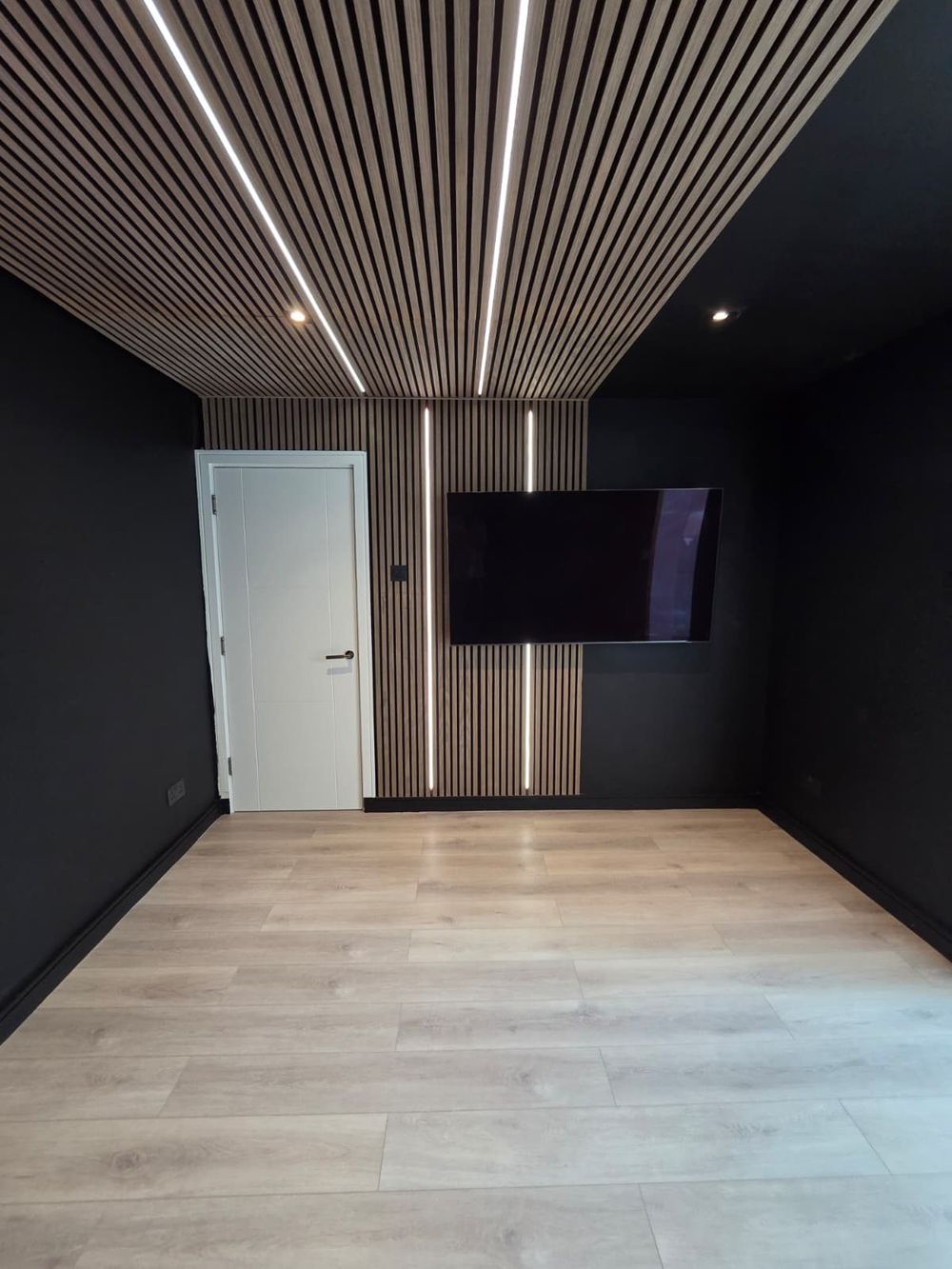 TV wall with slatted panelling and LED accents — Entertainment Room by TrustBuilt Projects