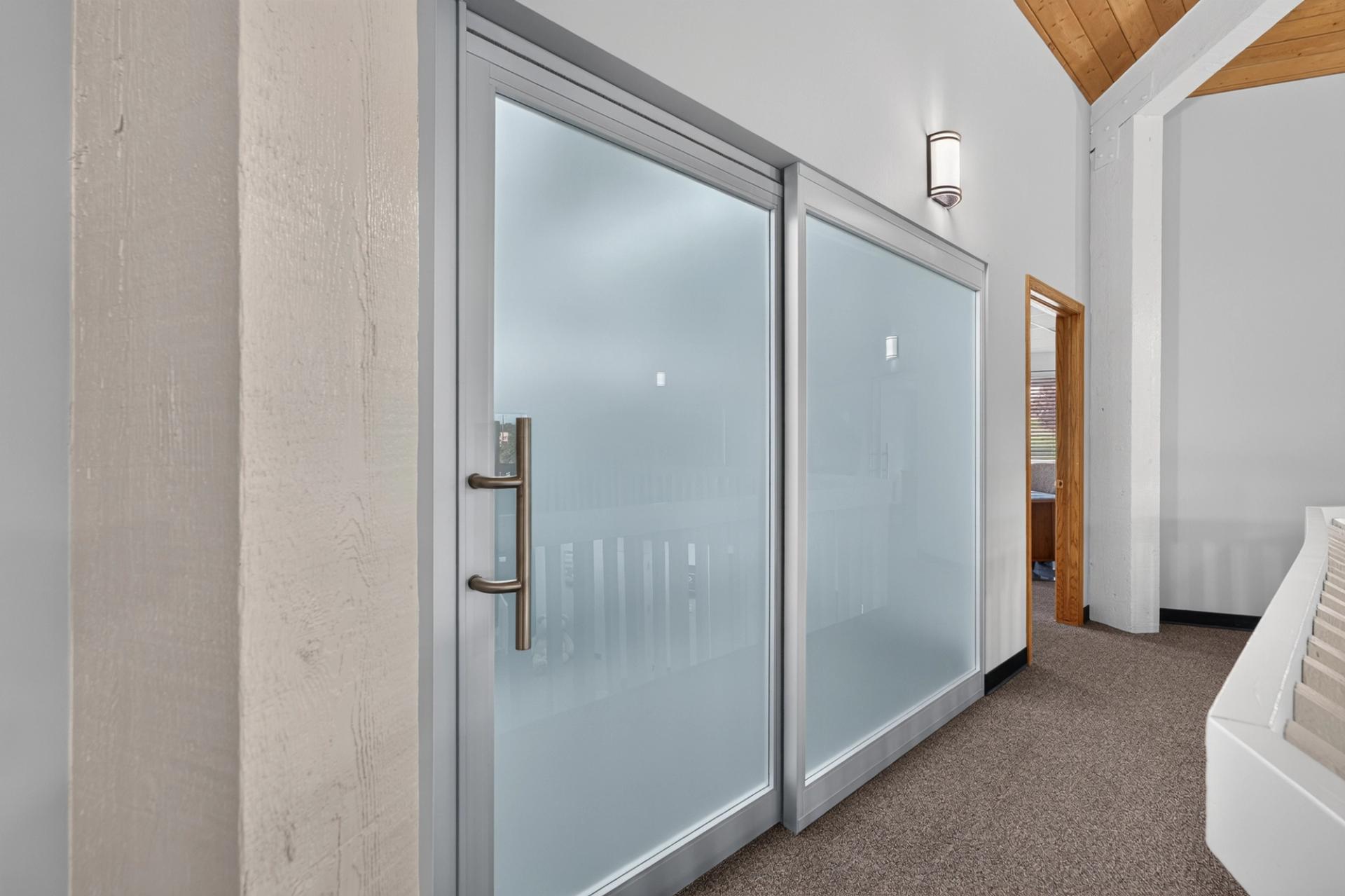 Frosted glass sliding door and fixed panel along the landing