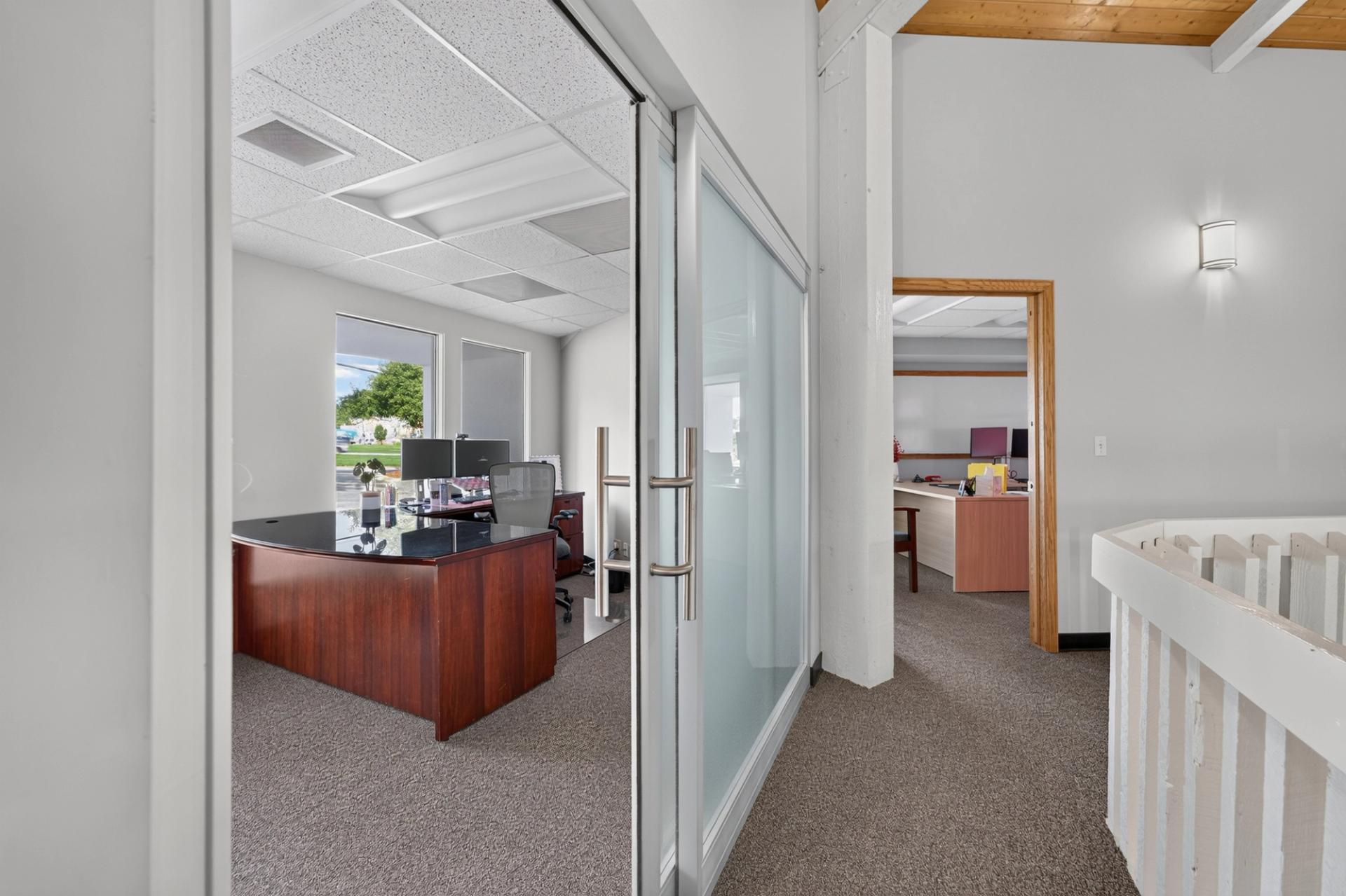 Private office behind a frosted glass ThinWall sliding door off the second floor landing at Tanya Patzner State Farm in Omaha