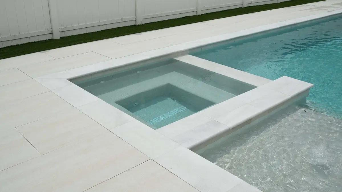 Modern pool deck installation with light-colored pavers in Orlando, FL