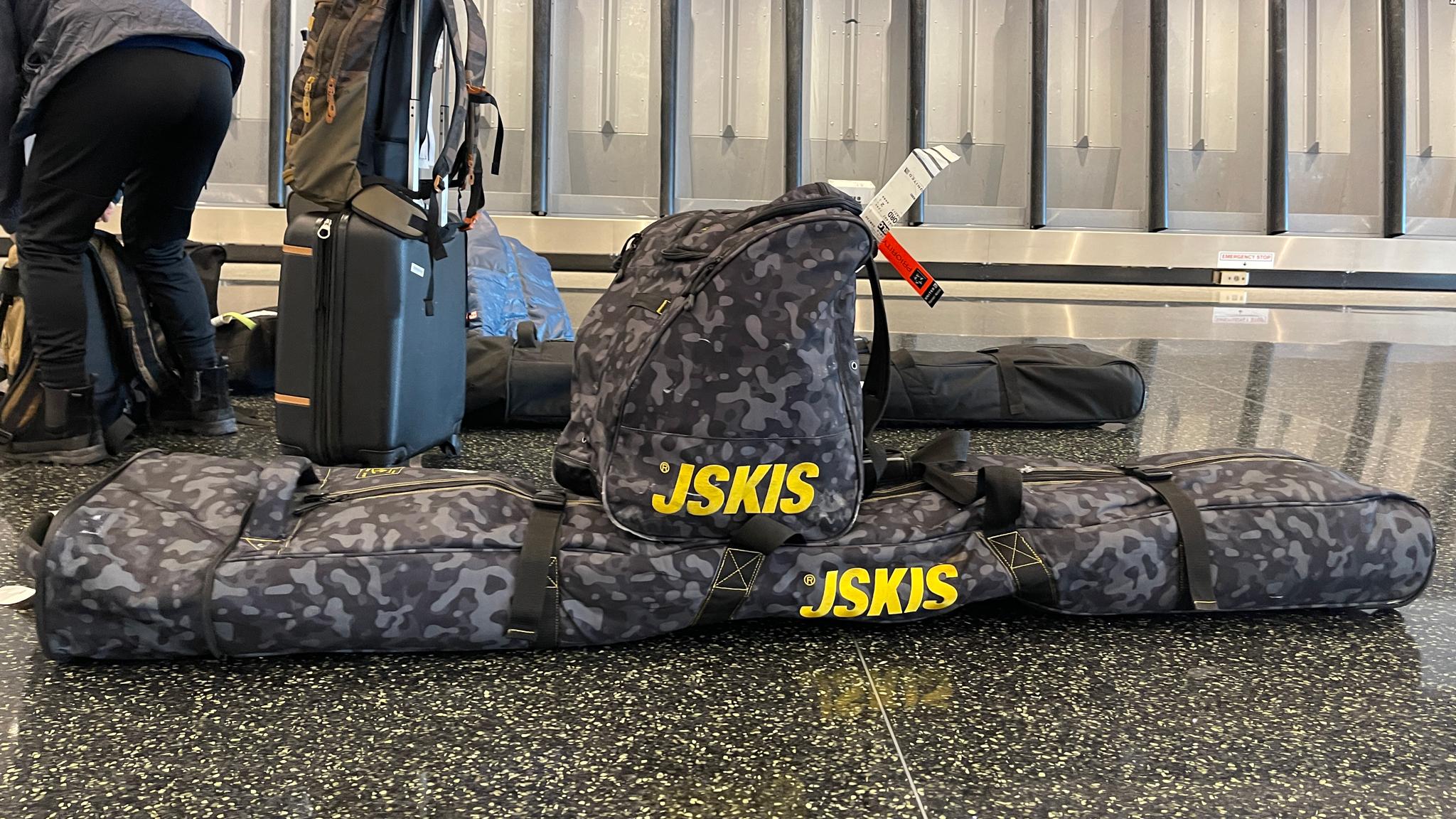 J skis camo boot and ski bag on the airport floor
