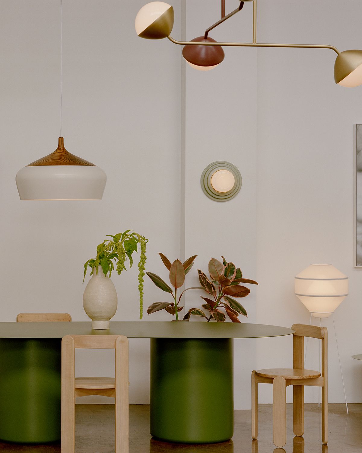 The Coco Flip showroom with a green dining table and white Coco pendant