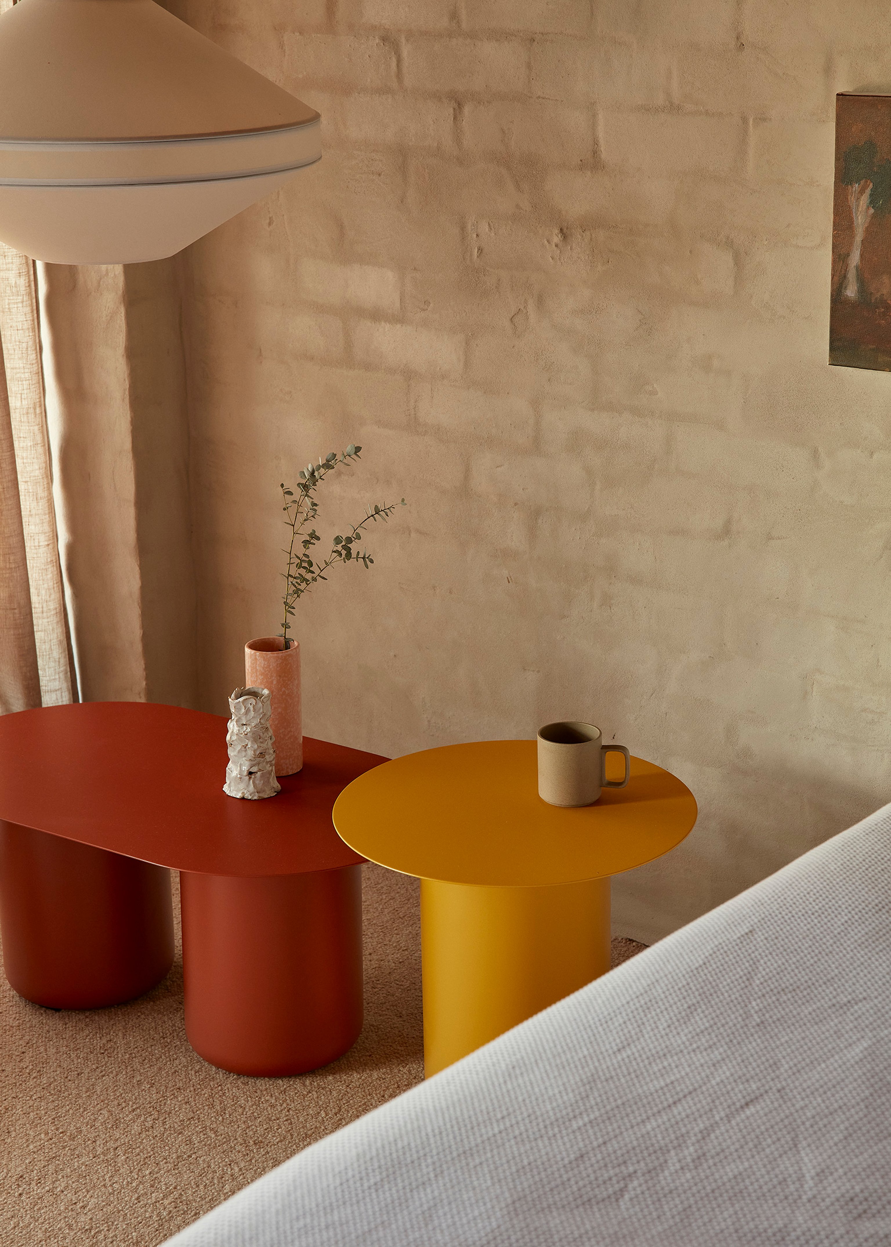 Red and Yellow Sequence Side Tables on a carpeting floor with rendered brick wall.