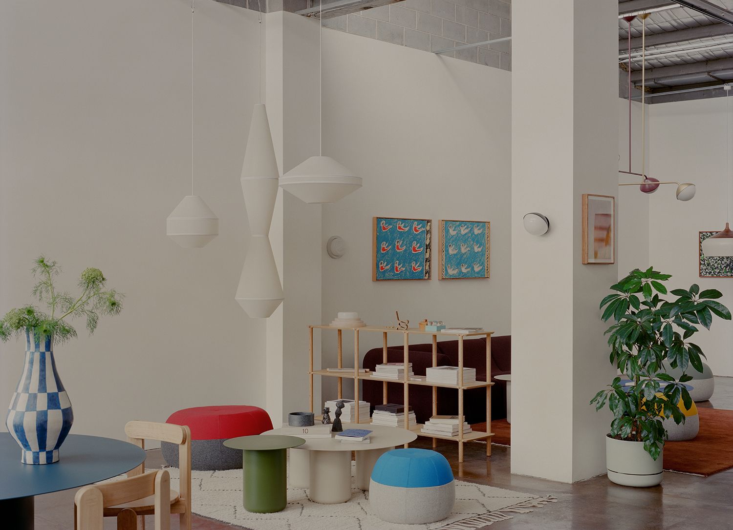 Coco Flip showroom with two puku ottomans. The walls of the room are white with colourful furniture and artwork