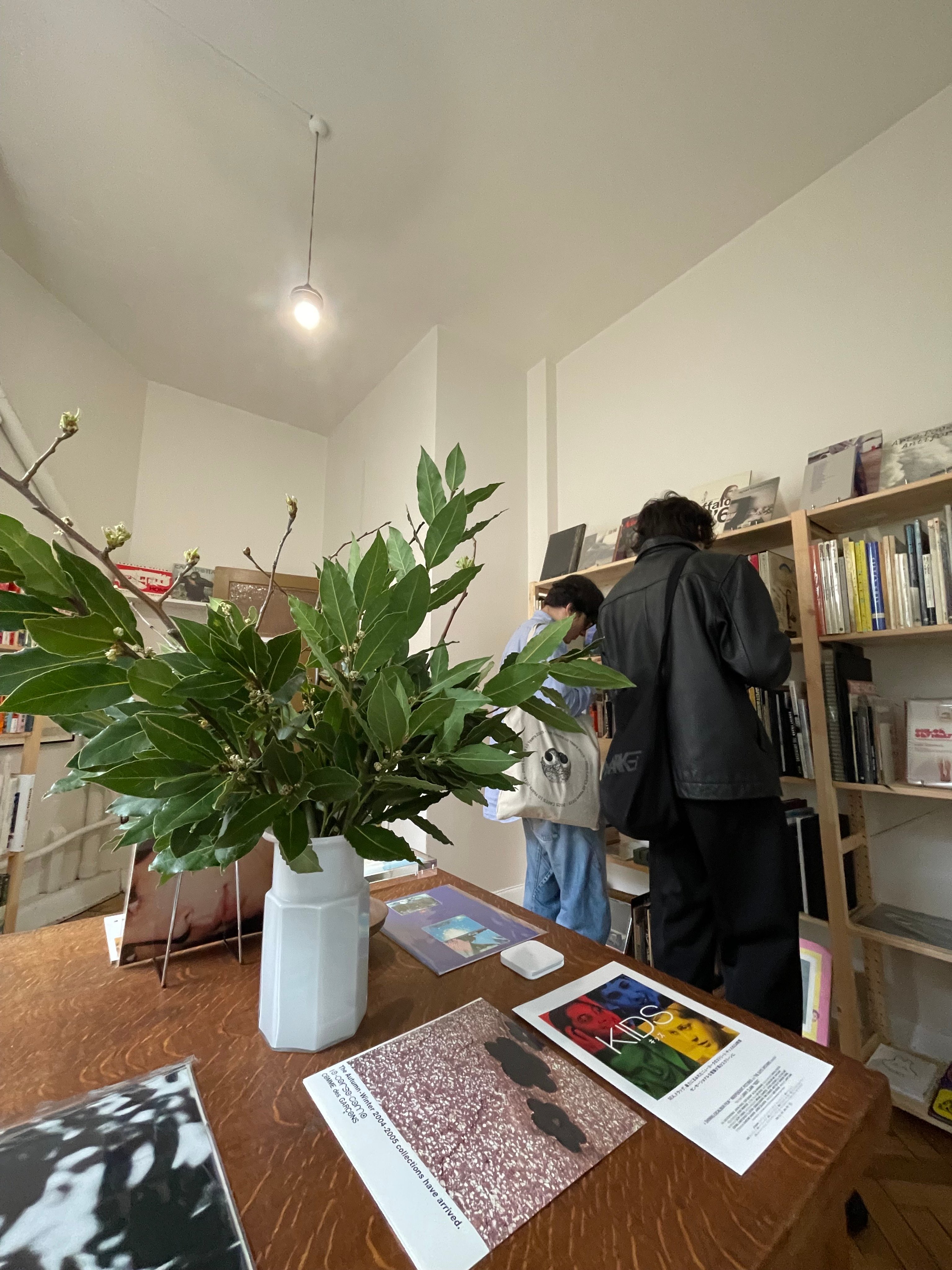 A portrait of Jessica Lillico and Sean Fennessy sitting at a dining table. Behind them on a rendered brick wall is a large abstract artwork.