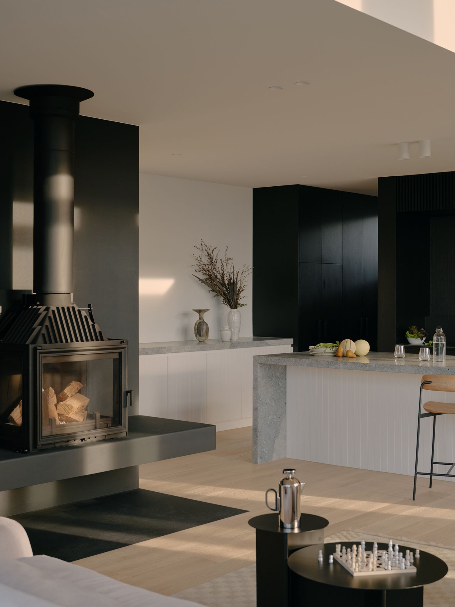 A expansive living room and kitchen with a dark fireplace