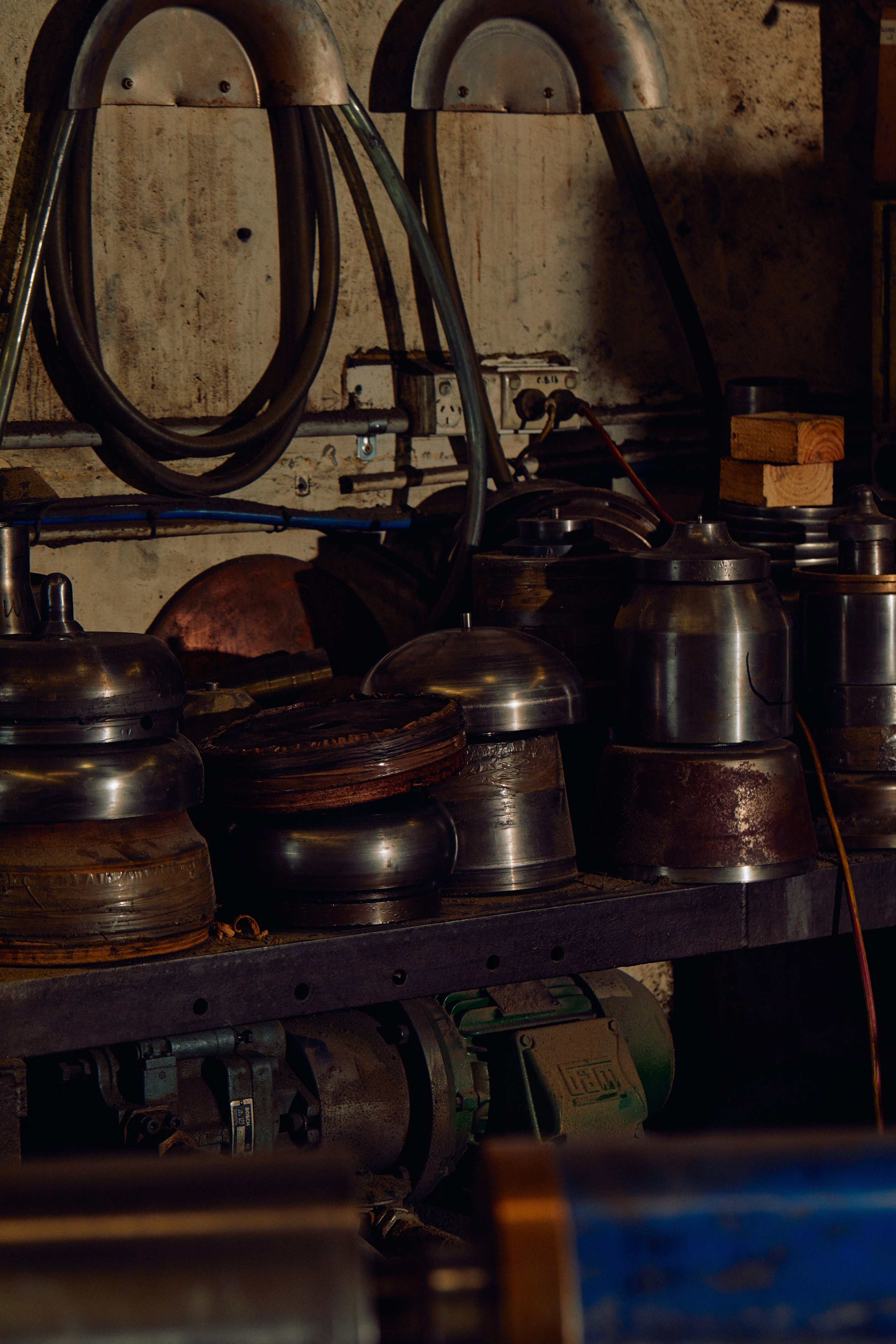 A bunch of old metal objects and tools sitting on a messy benchtop in an industrial factory