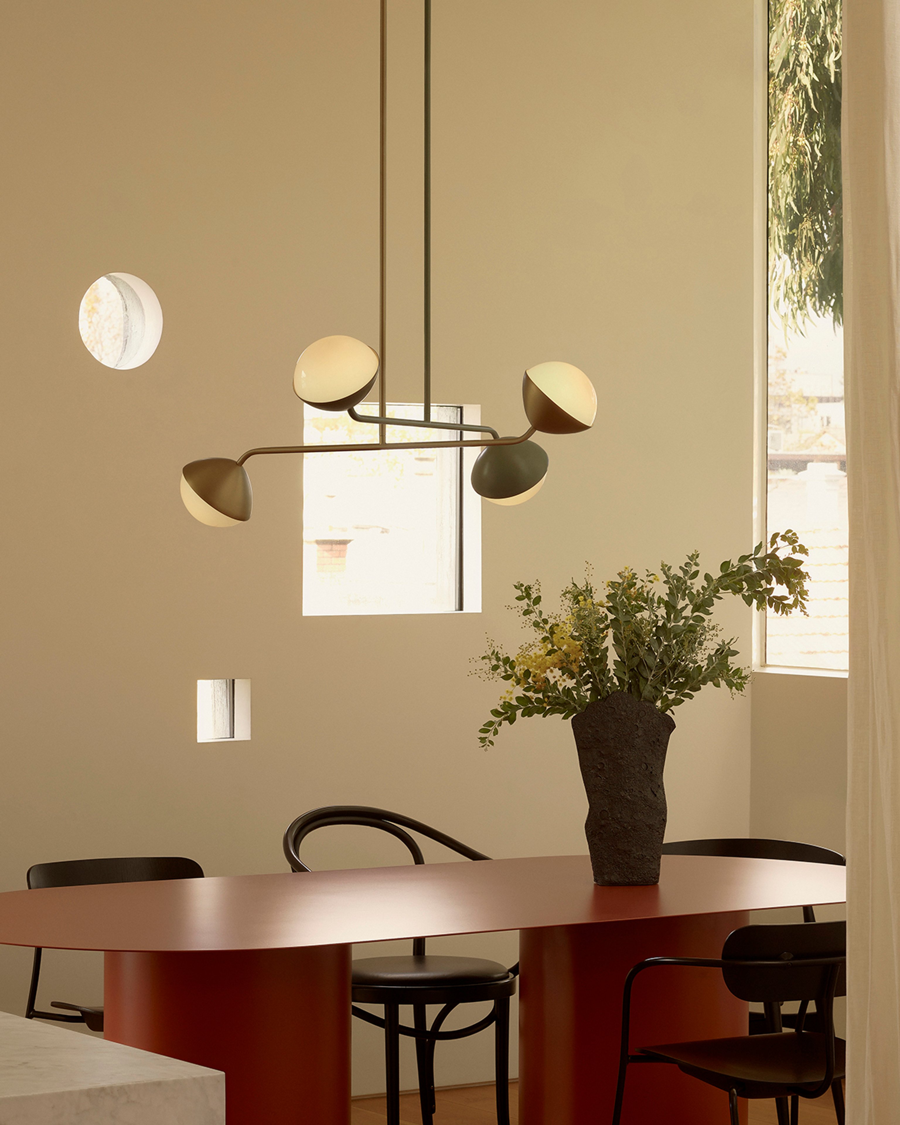 Jolly double rod pendants hanging in a dining room with warm tones.