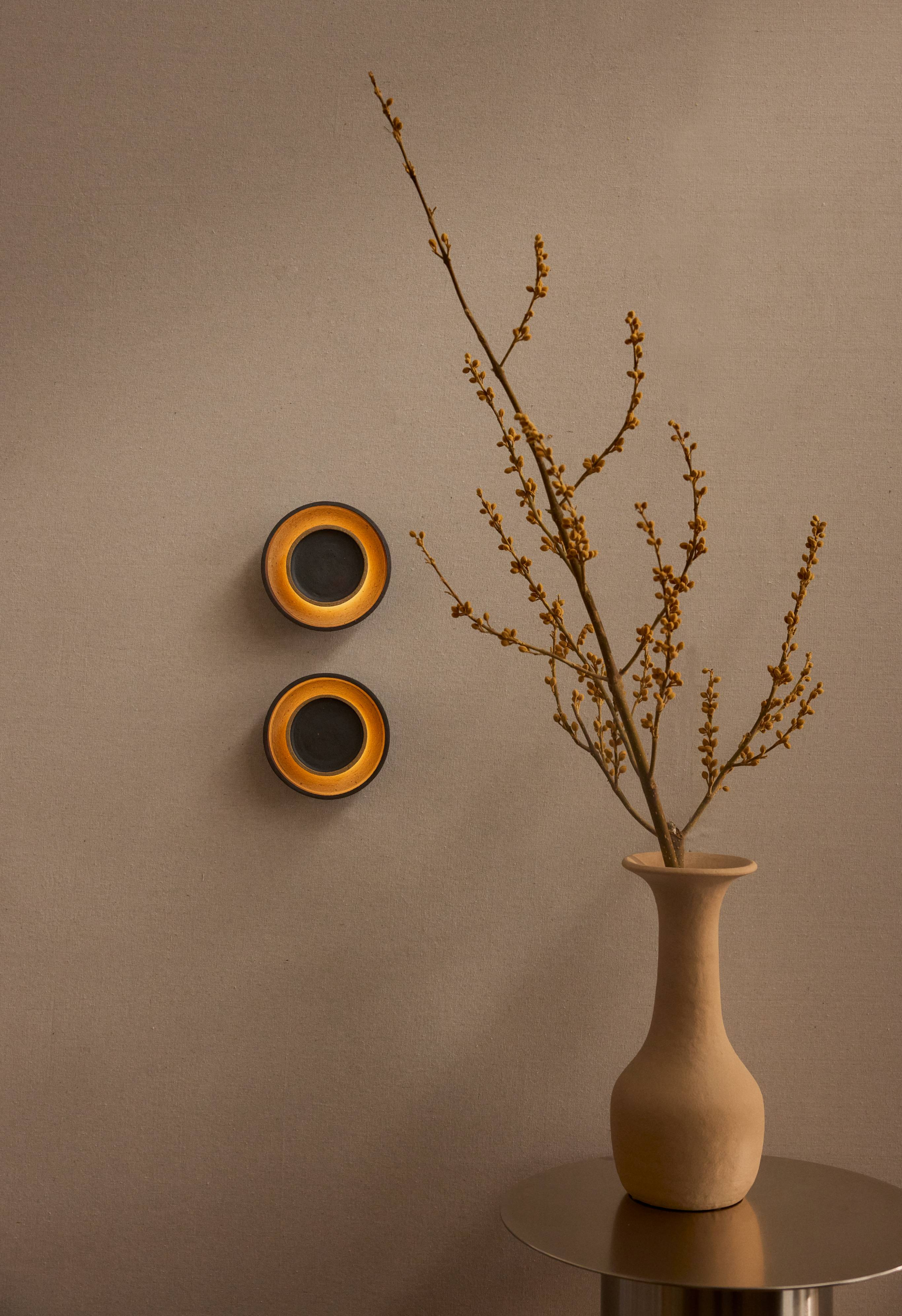 A pair of Chorus Wall Lights installed on a warm coloured wall.