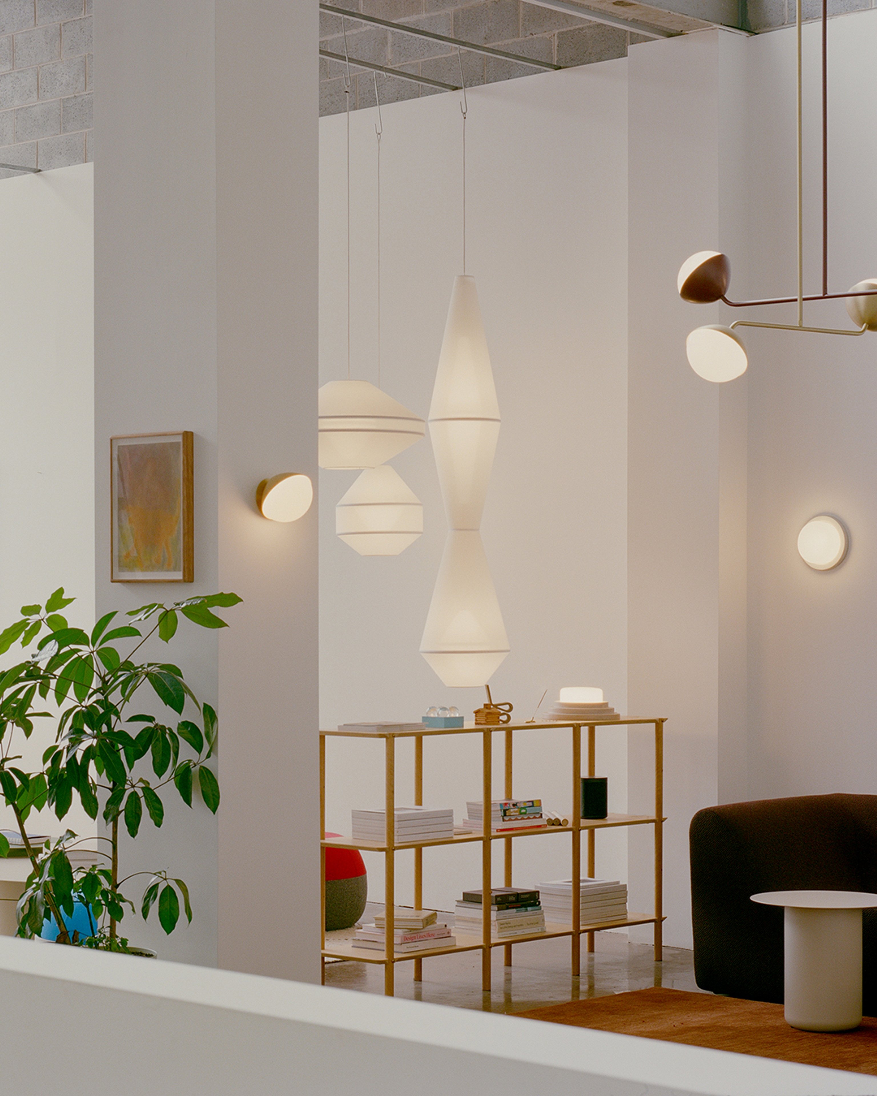 Jolly wall light and Jolly double rod pendants in the Coco Flip showroom surrounded by other statement lighting and furniture