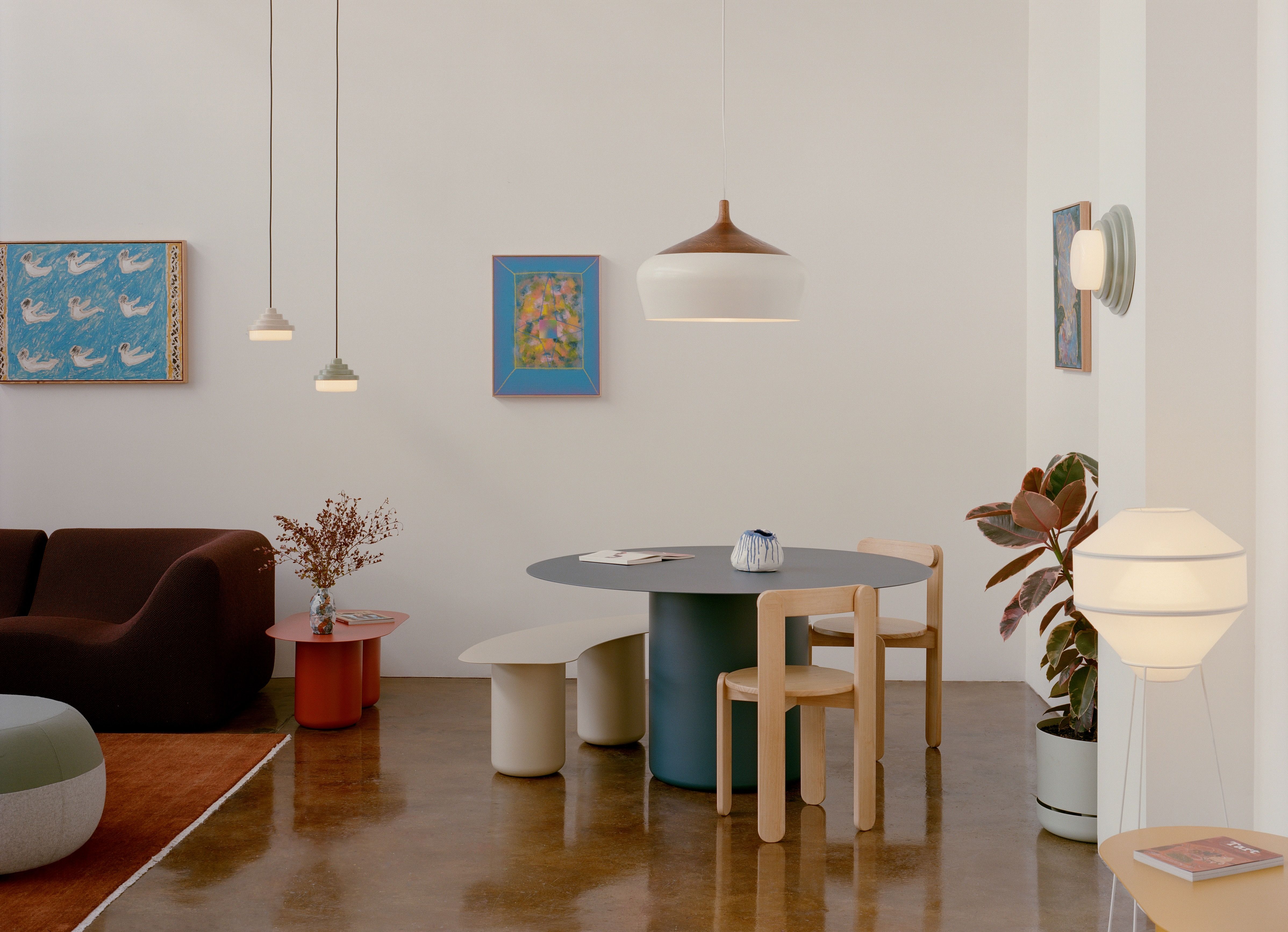 The Coco Flip showroom with a deep blue round dining table and white Coco pendant