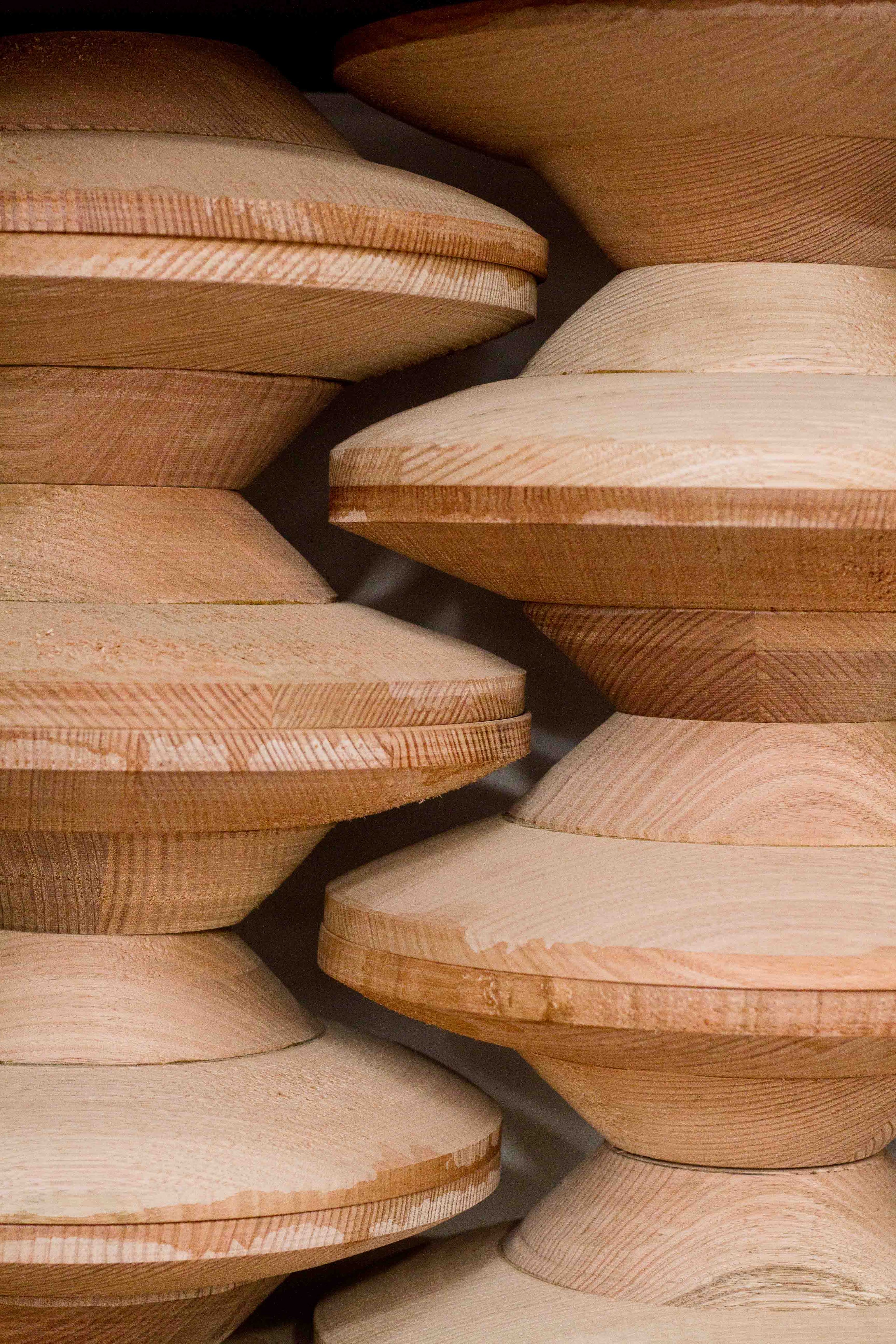 Laminated timber forms for Coco Pendants stacked up on top of each other.