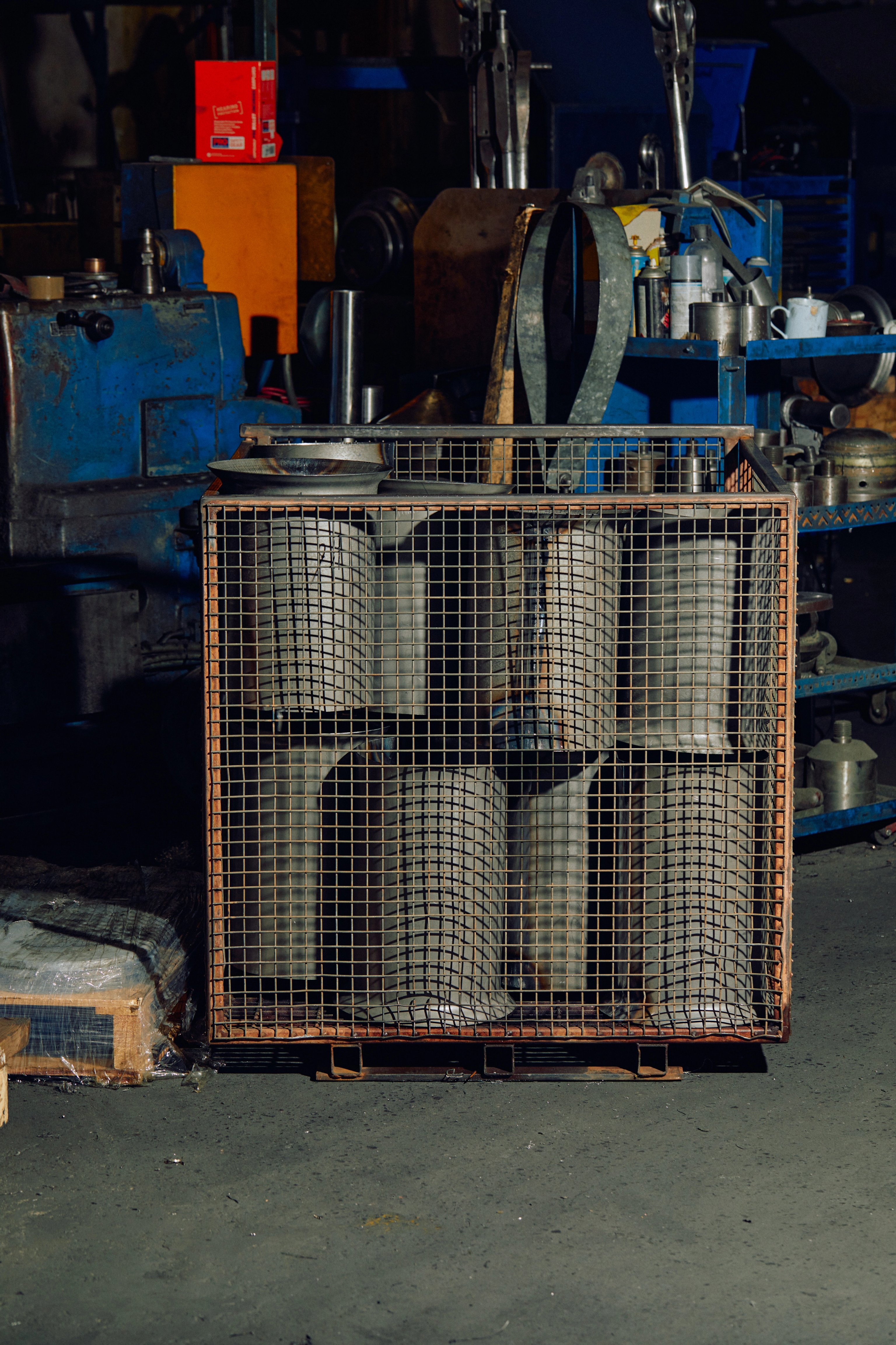 A cage of metal drums in an industrial metal factory