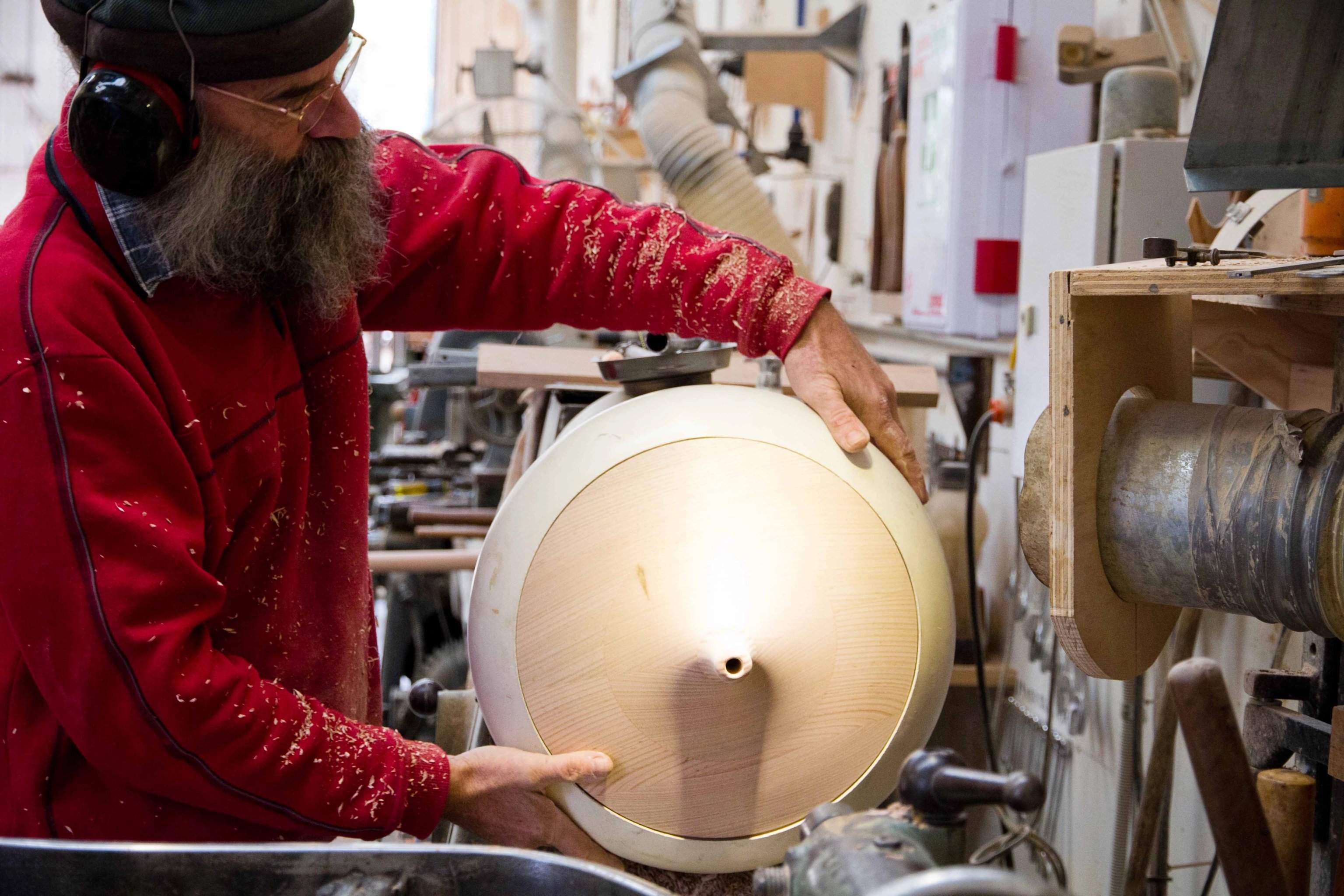A man holding an aluminium shape over a timber form to check the fit.