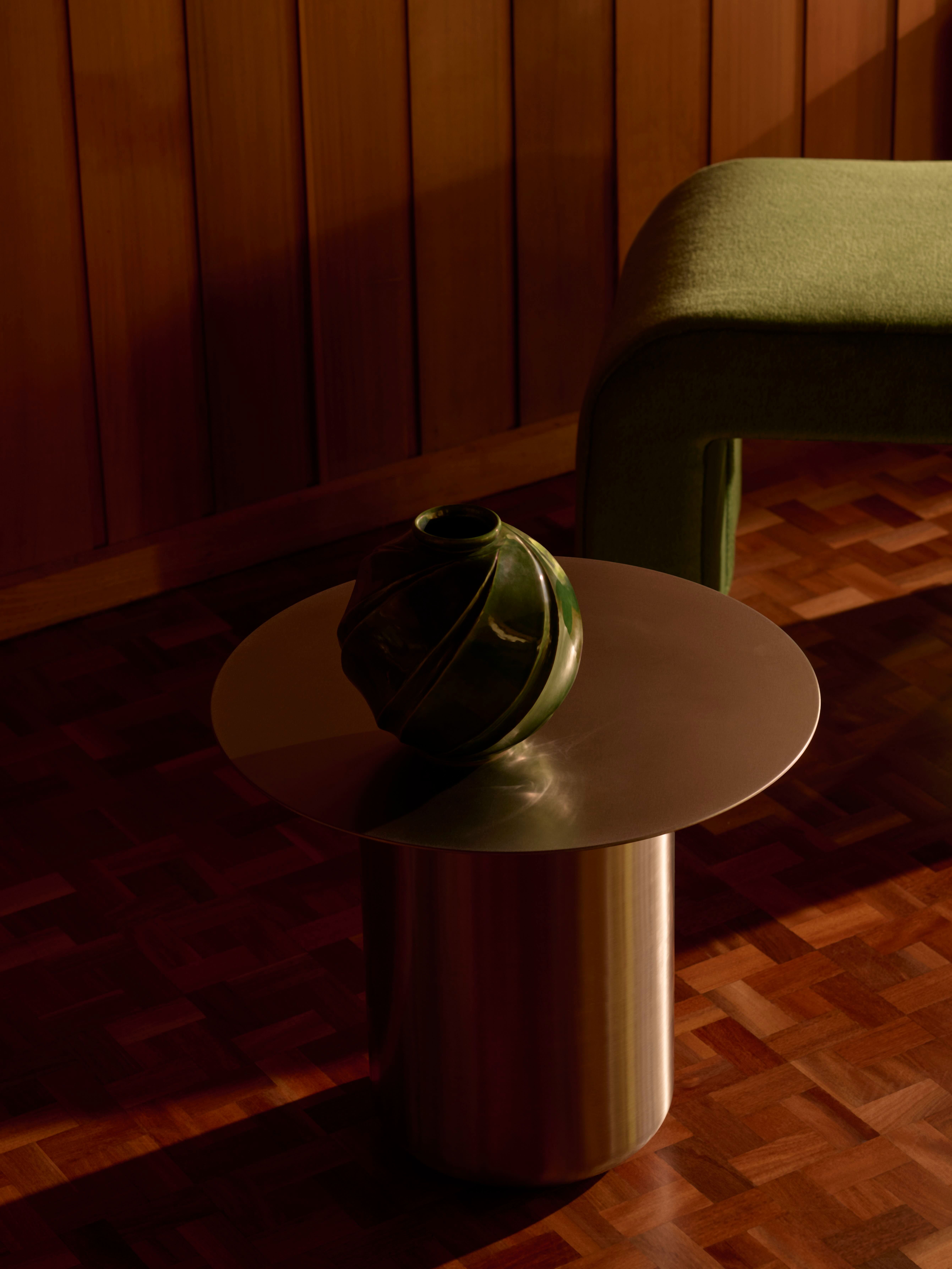 A Sequence 01 Table in stainless steel in a dark, moody room.