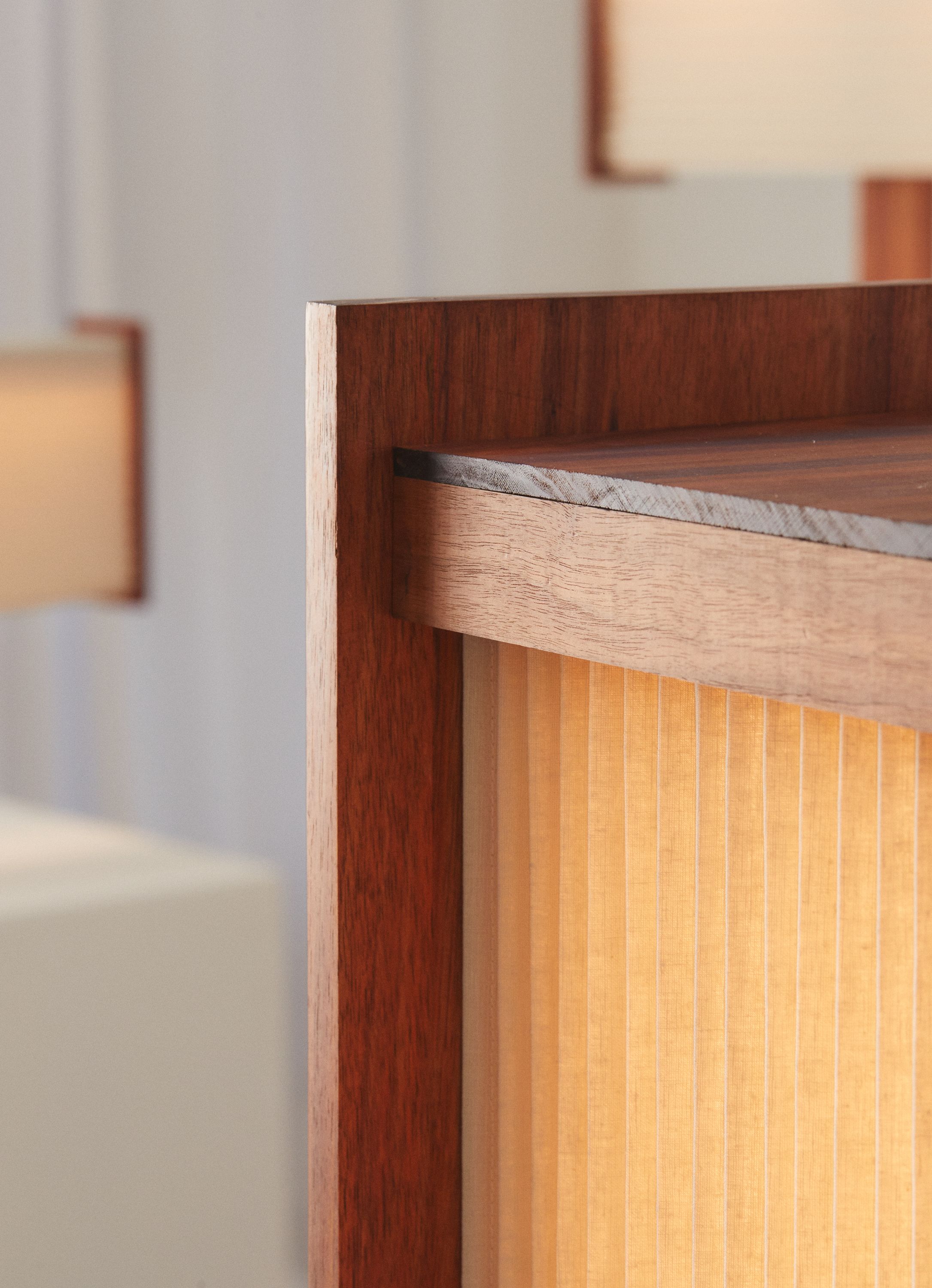 A close up view of a Linear floor lamp, with intricate pleated linen and timber detaling