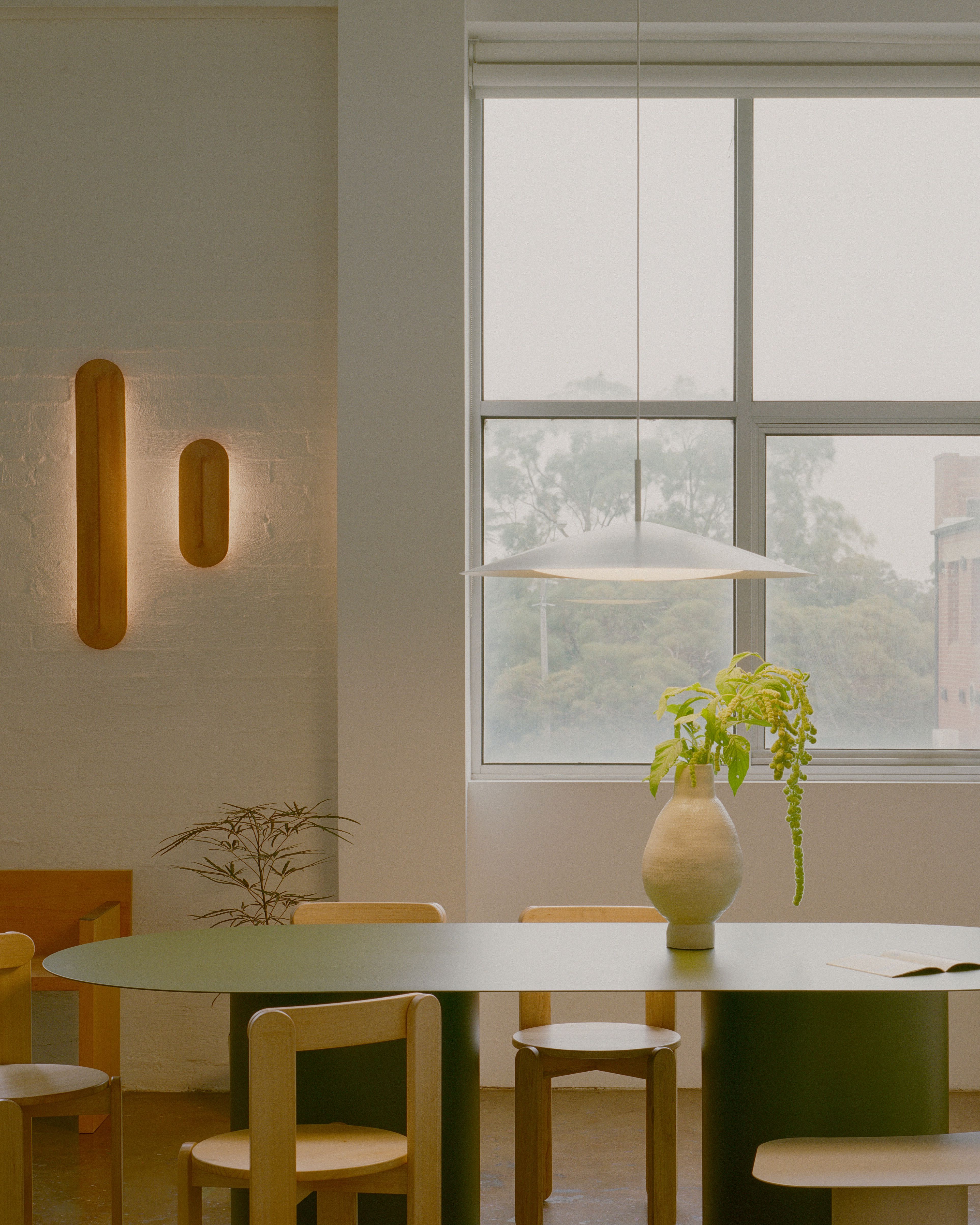 Pinch 400 and Pinch 900 Terracotta wall lights fitted to a white brick wall in the Coco Flip showroom