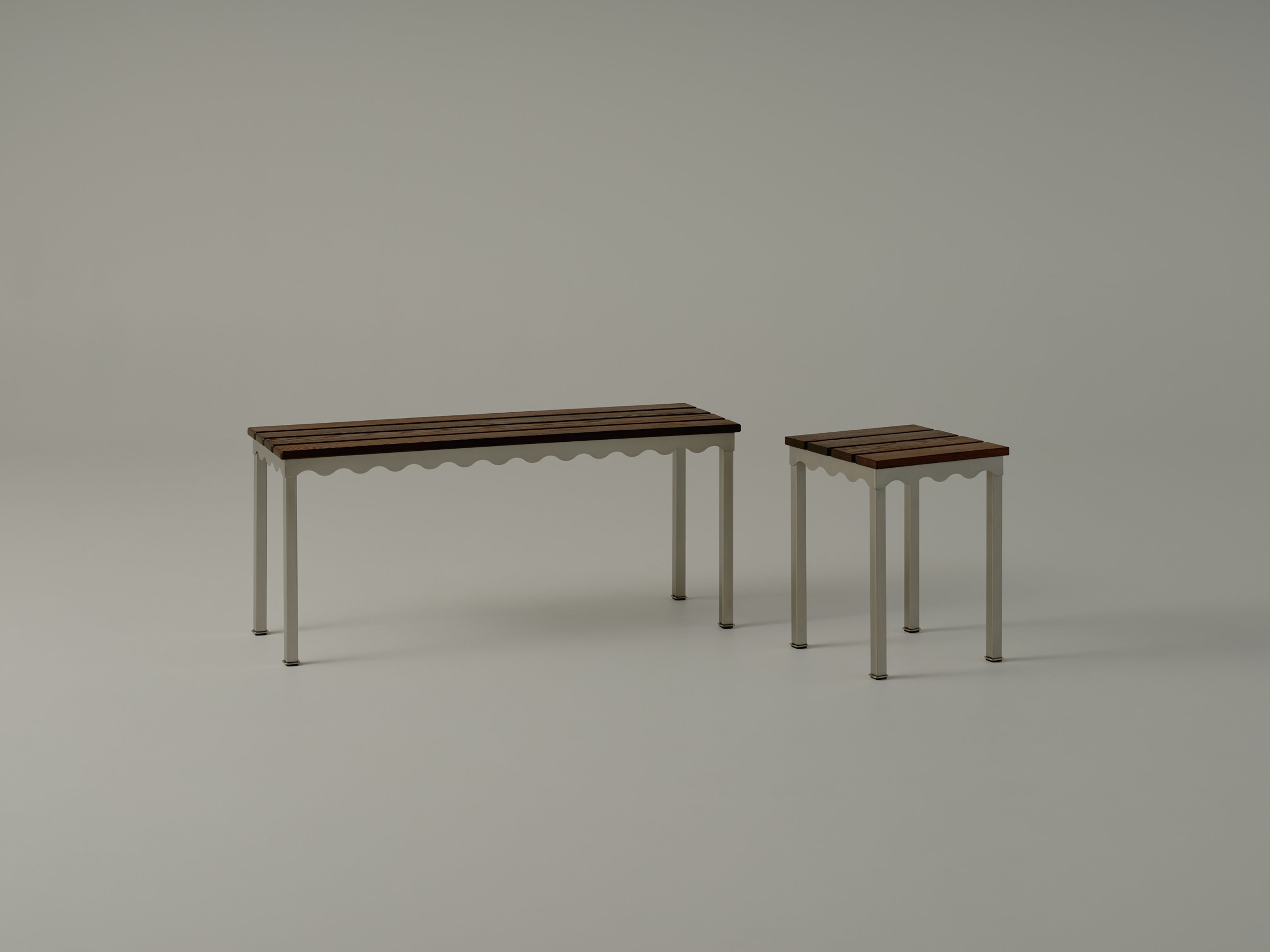 A close up of stainless steel tables with curved spun legs and slender tops