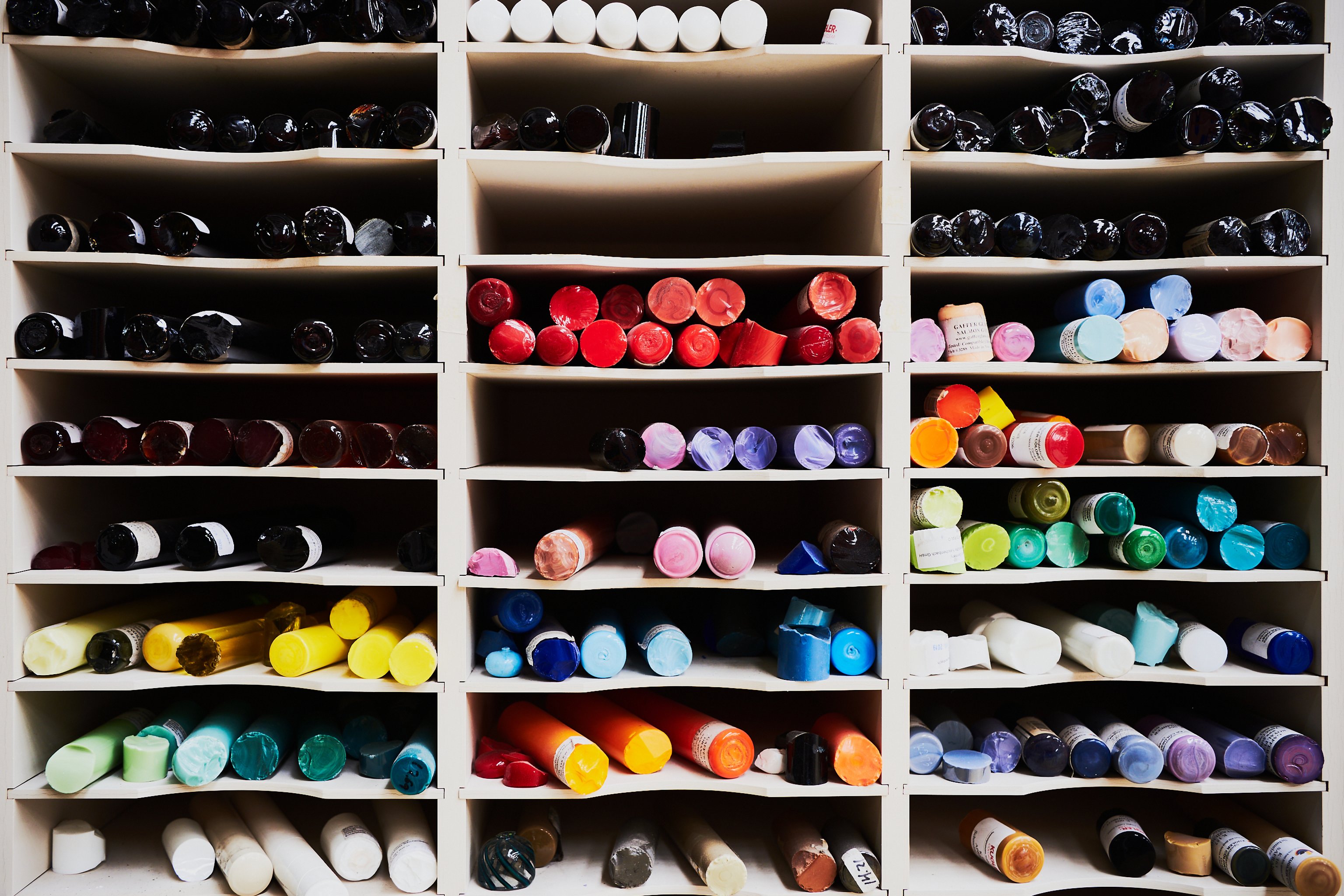 Shelves filled with different coloured glass rods.