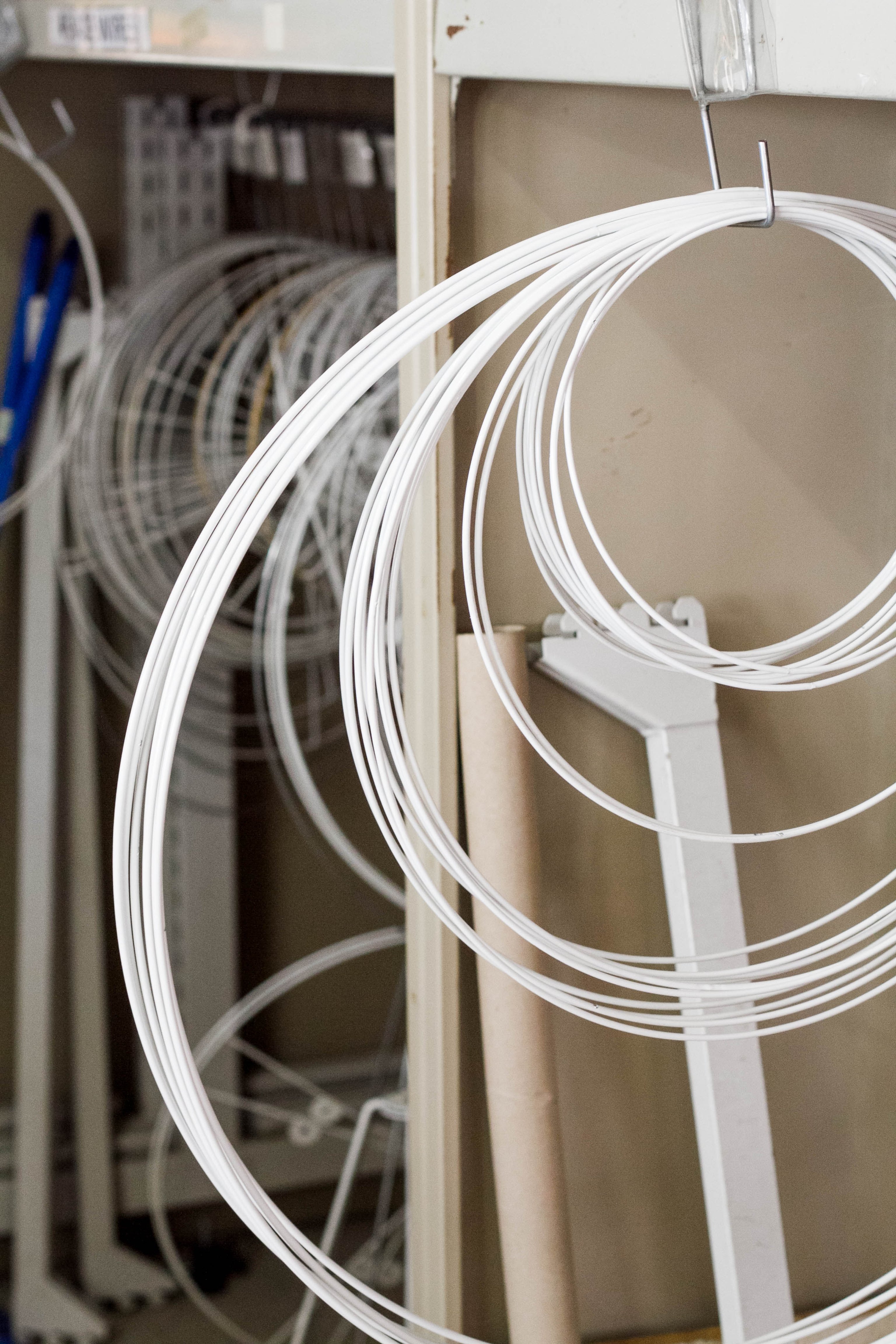 A stack of wire rings hanging on hooks on shelving