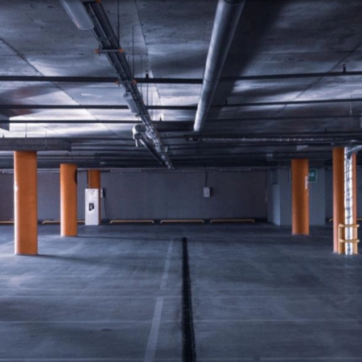 A dimly-lit parking garage with orange pillars