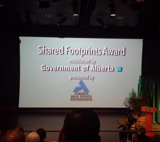 Presentation screen reading 'Shared Footprints Award Established by Government of Alberta - Presented by Alberta Real Estate Foundation'