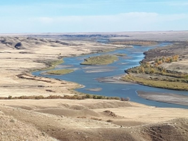 A river flows through a dry low-lying area