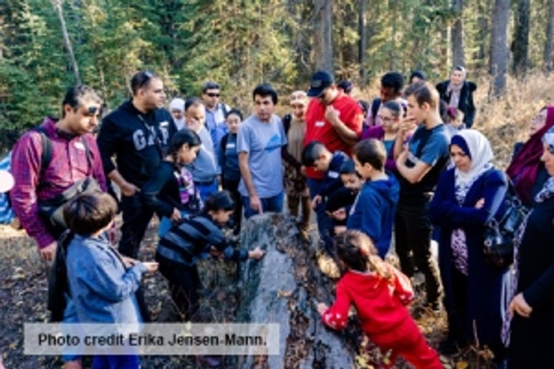 A group of people out in nature, with credit text reading "Photo credit Erika Jensen-Mann"