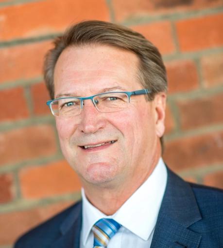 Jim Saunders headshot against red brick backdrop