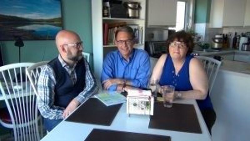 Three people pose for a photo at a table