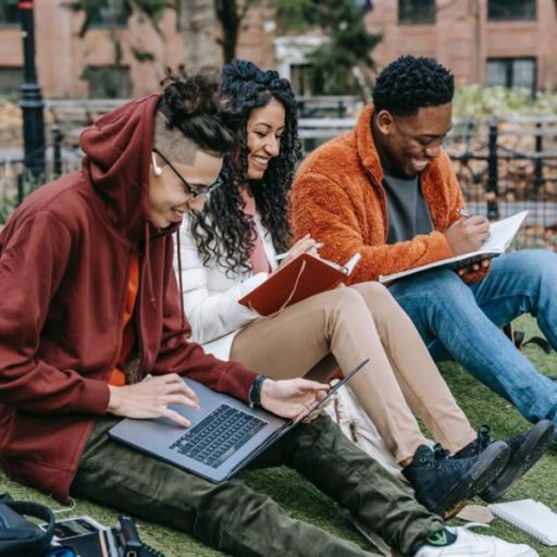 Three students laugh while studying together