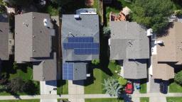 Aerial photo of a home with solar panels on the roof.