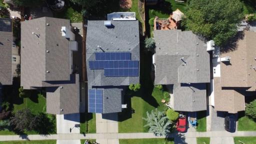 Aerial photo of a home with solar panels on the roof.