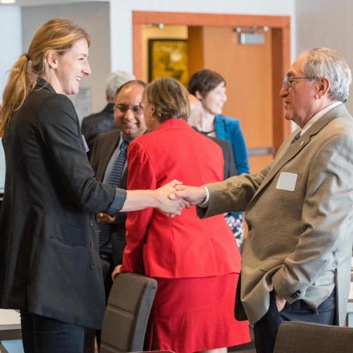 Two professionals shake hands at a business meeting