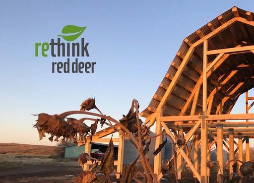 Photo of a barn frame with dead sunflowers in the foreground, with a 'Rethink Red Deer' logo in the foreground.