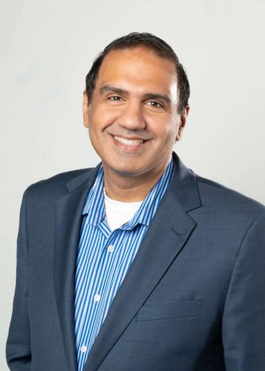 Anand Sharma headshot on a white backdrop