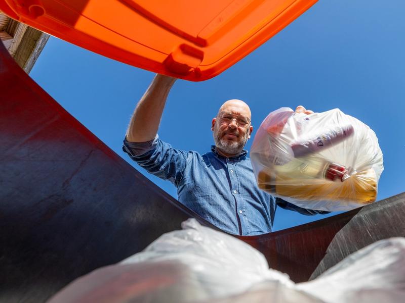 Inwoner gooit afval in de container