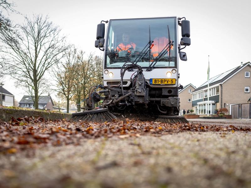 Veegwagen veegt bladafval