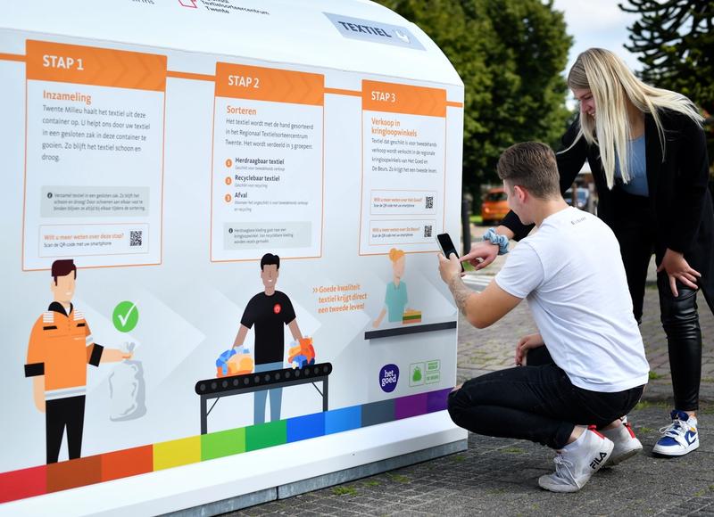 jongeren scannen qr-code textiel container