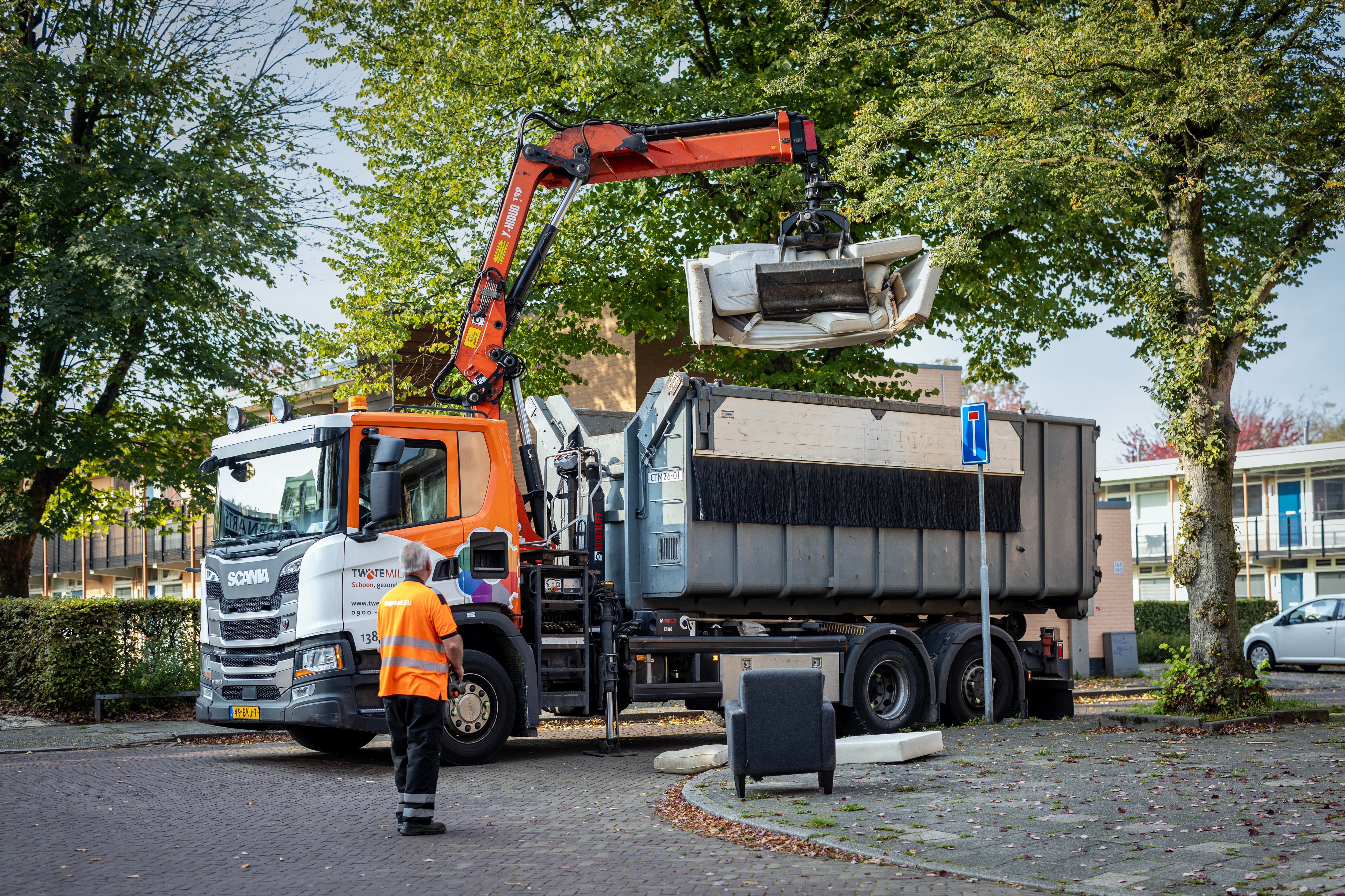 Vuilnisman takelt grofvuil in vuilniswagen