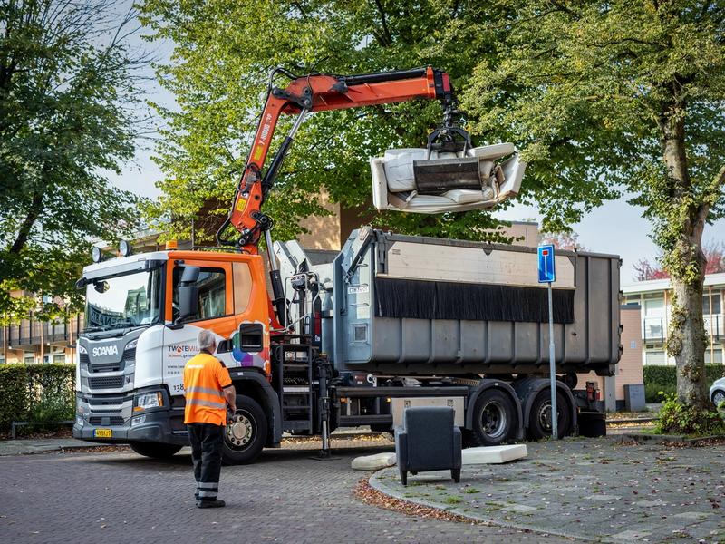 Vuilnisman takelt grofvuil in vuilniswagen