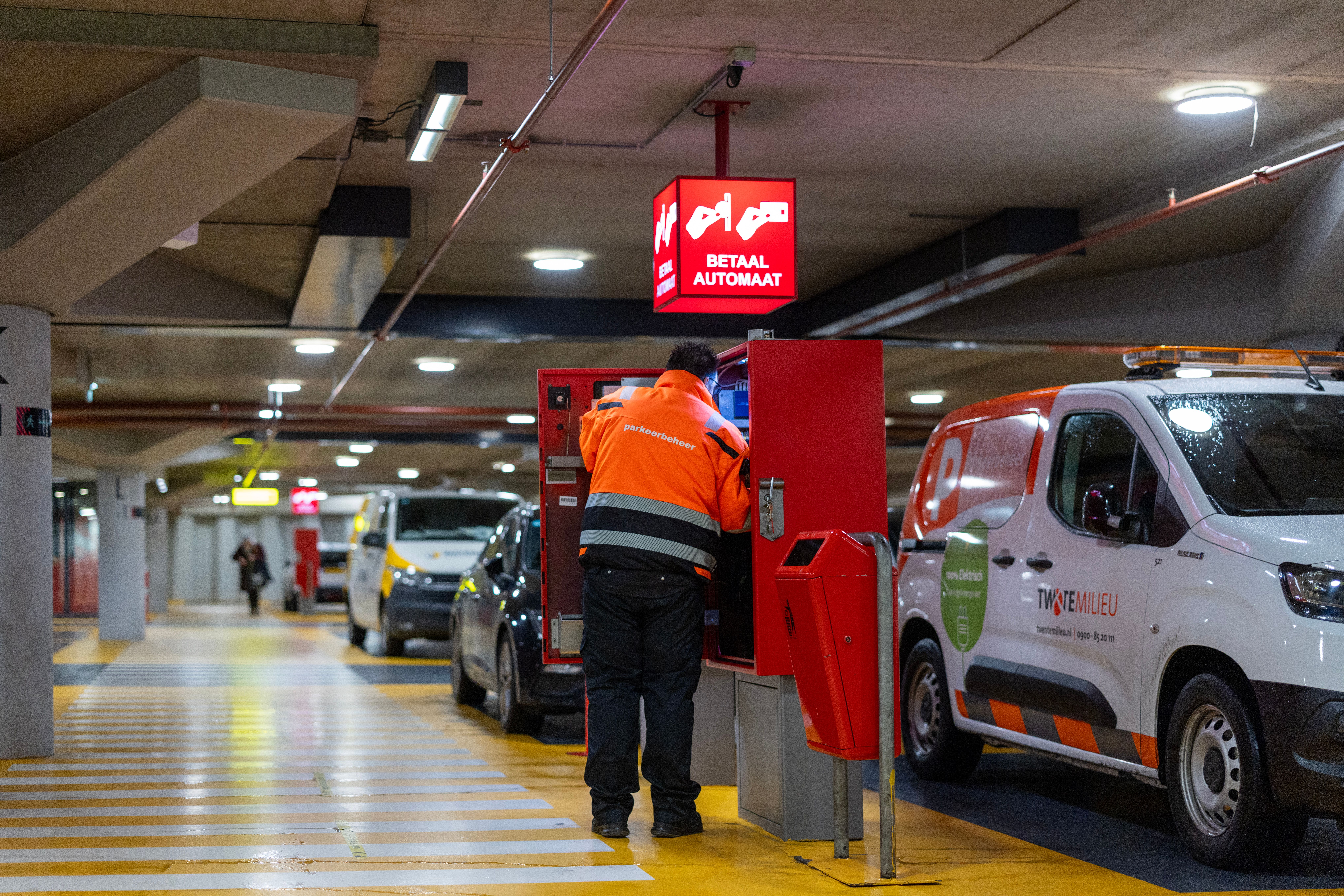 Medewerker parkeerbeheer controleert betaalautomaat