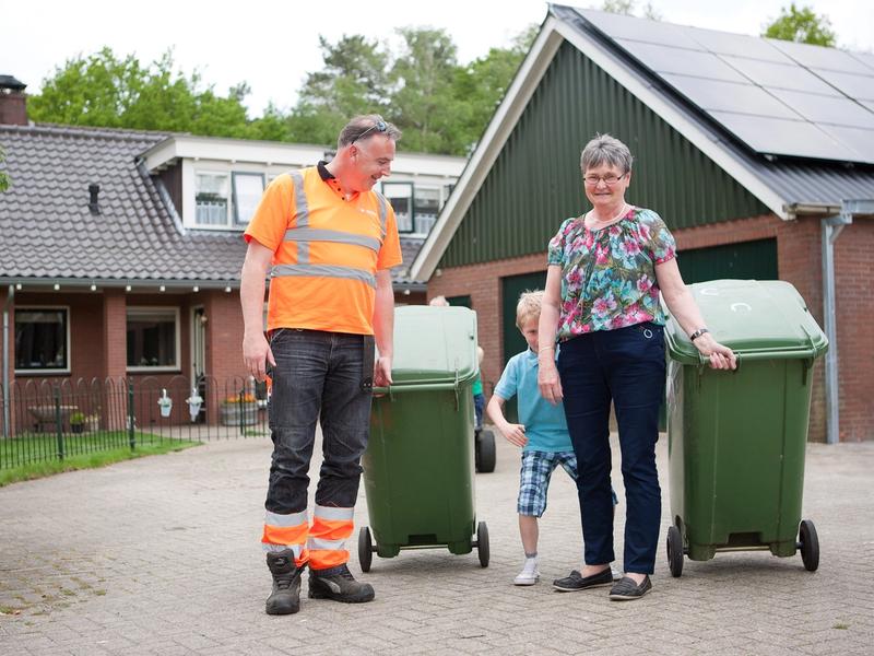 Vuilnisman en inwoner zetten de gft-container buiten