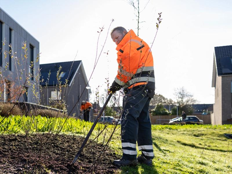Medewerker Twente Milieu schoffelt plantsoen