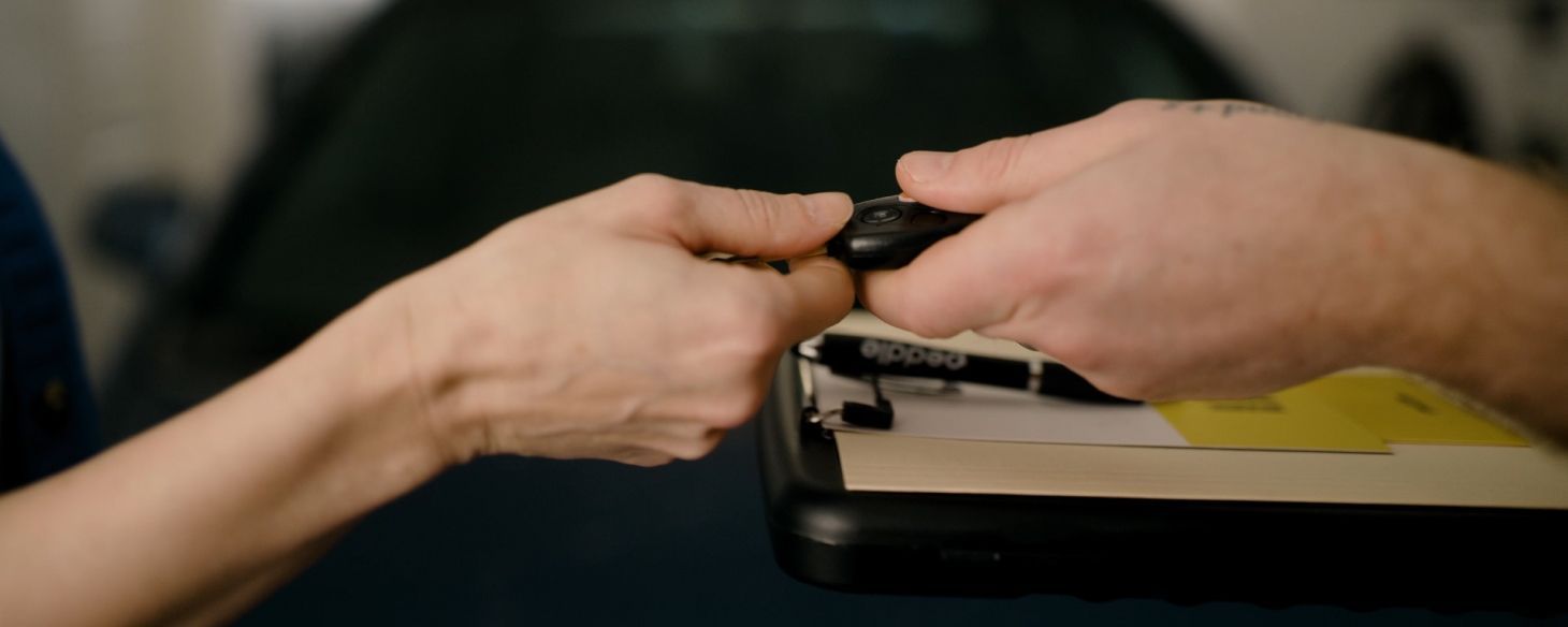 Seller handing over car keys to a Peddle buyer after selling their car