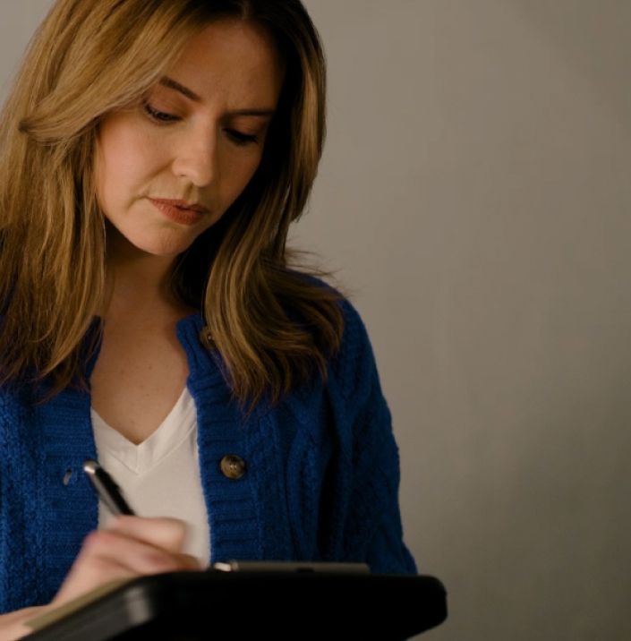 Woman filling out paperwork to complete the process of selling her car